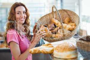 Pretty brunette picking out croissant