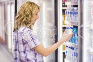 Smiling blonde woman taking a water bottle