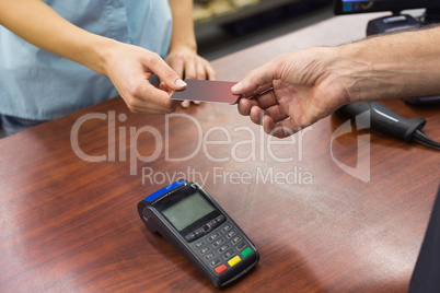 Woman at cash register paying with credit card