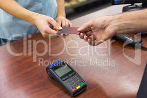 Woman at cash register paying with credit card