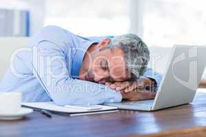 Businessman sleeping on laptop computer