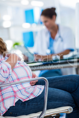 Close up of pregnant woman with one hand on belly