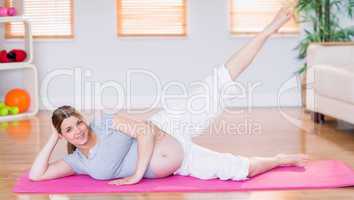 Pregnant woman doing exercise on exercise mat