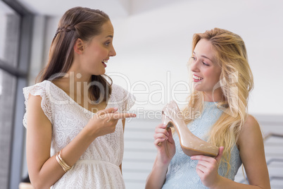 Happy women showing a heel shoe