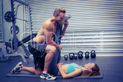 Muscular couple doing a leg stretching