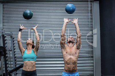 Muscular couple throwing ball in the air