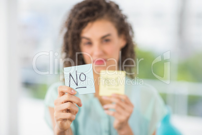 Smiling businesswoman holding yes and no sticks