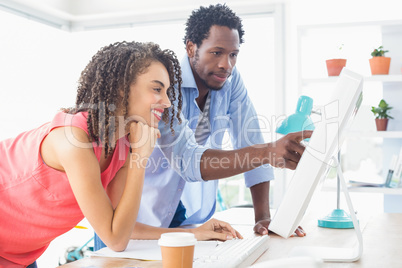 Two creative business colleagues watching the computer