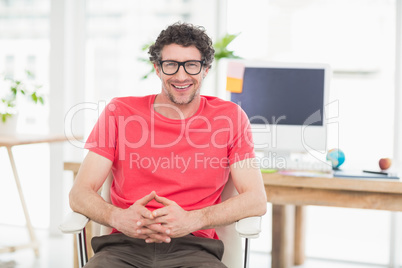 Handsome businessman sitting on a swivel chair and using his la