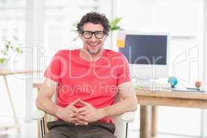 Handsome businessman sitting on a swivel chair and using his la