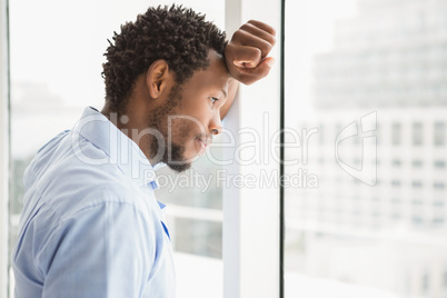 Young concentrated businessman looking out of the window