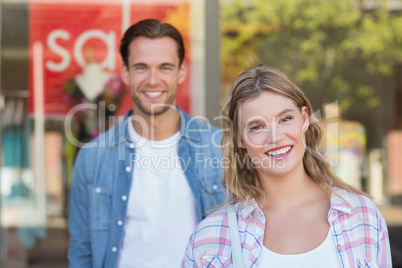 happy couple standing in front of a SALE sign