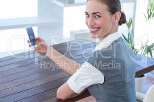 Happy businesswoman using her smartphone