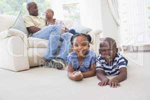 Happy siblings sitting on the floor watching television