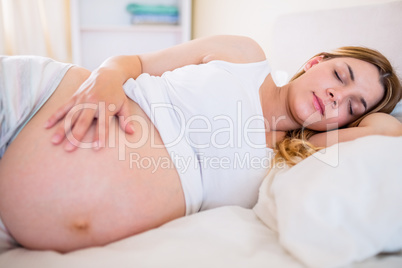 Pregnant woman sleeping on bed