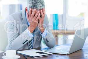 Depressed businessman with hands on head