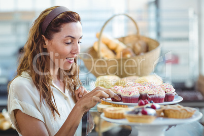 Pretty brunette choosing cupcake