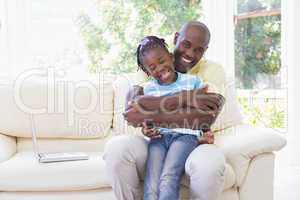 Happy smiling father to hug with her daughter in couch