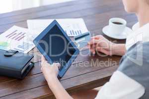 Businesswoman using tablet pc and holding credit card