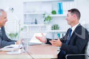 Two businessmen sitting and speaking