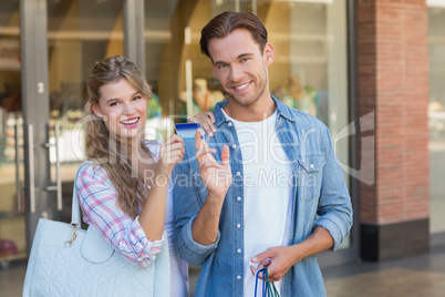 Portrait of a happy couple showing their new credit card