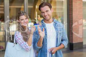 Portrait of a happy couple showing their new credit card