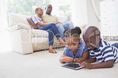 Happy siblings using digital tablet