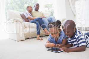 Happy siblings using digital tablet