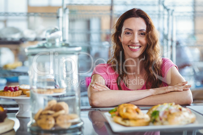 Pretty brunette smiling at camera behind counter