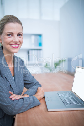 Smiling businesswoman in front of her laptop