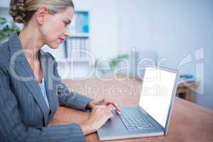 Attentive businesswoman working on laptop