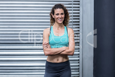 Smiling muscular woman with arms crossed