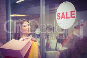 Portrait of smiling woman with shopping bags looking at camera