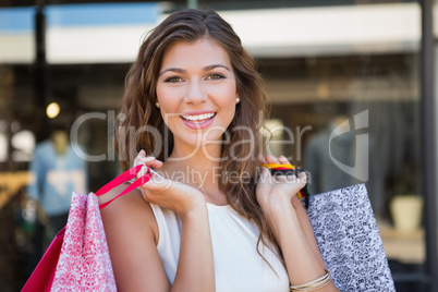 Portrait of smiling woman with shopping bags looking at camera