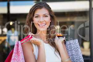 Portrait of smiling woman with shopping bags looking at camera