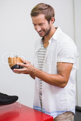 Young happy man smiling and looking at a shoe