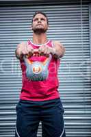 Muscular man lifting a kettlebell