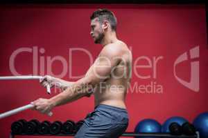 Muscular man exercising with rope