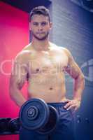 Portrait of muscular man lifting dumbbell