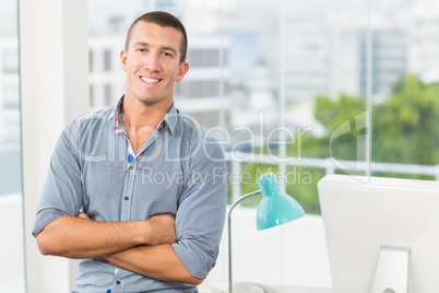 Smiling businessman in grey shirt in his office