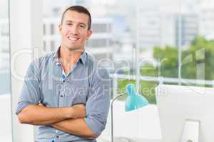 Smiling businessman in grey shirt in his office