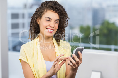 Smiling businesswoman holding her phone