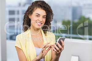 Smiling businesswoman holding her phone