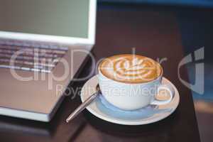 Close-up of laptop and coffee on table