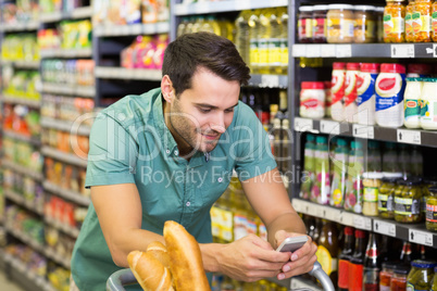 Smiling man buy food and using his smartphone