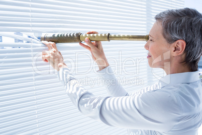 Businesswoman looking through field-glass in the office