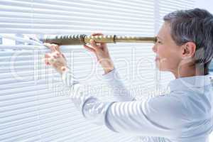 Businesswoman looking through field-glass in the office