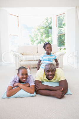 Happy smiling couple lokking at camera with their daugther