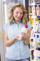 Smiling woman looking at a milk bottle