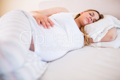 Pregnant woman sleeping on bed